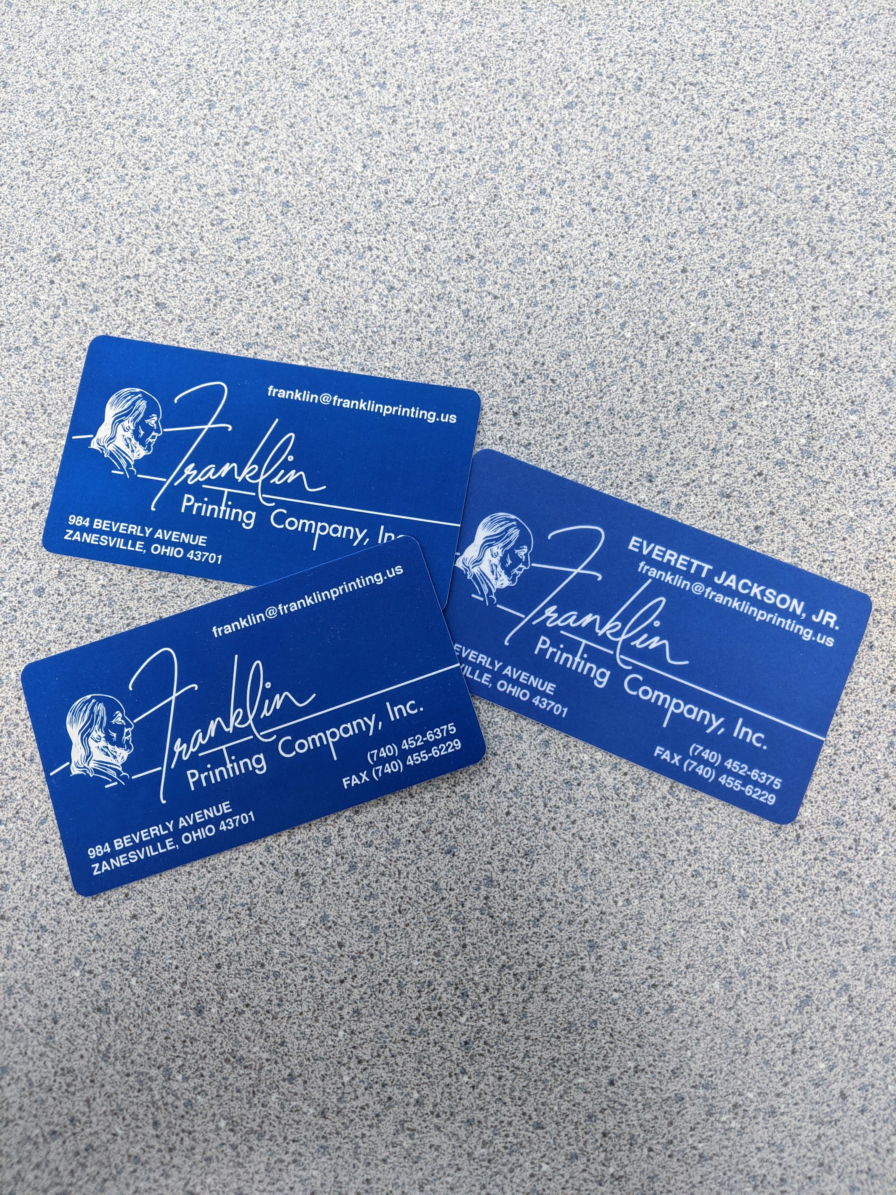 Stack of blue Franklin Printing business cards on a worktop