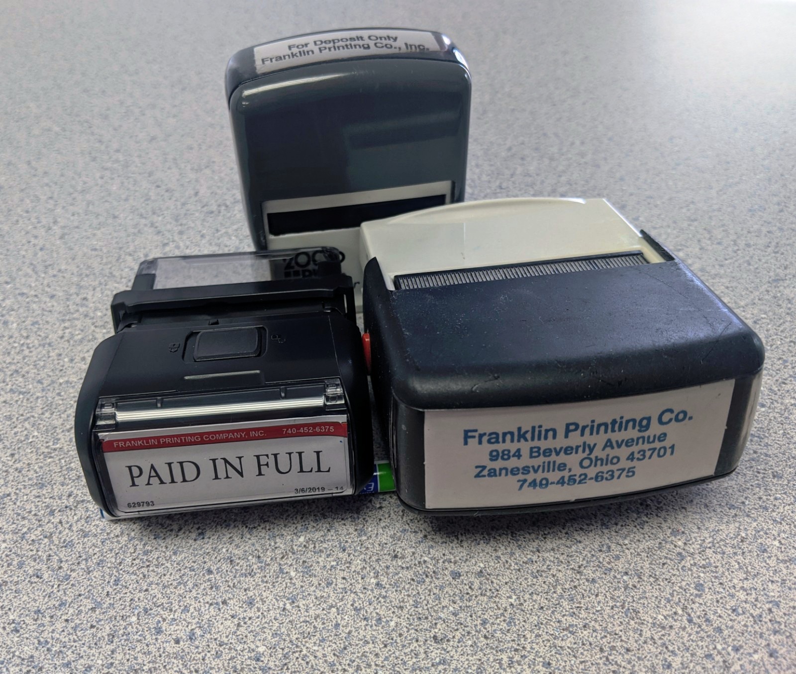 Three self-inking rubber stamps on a desk